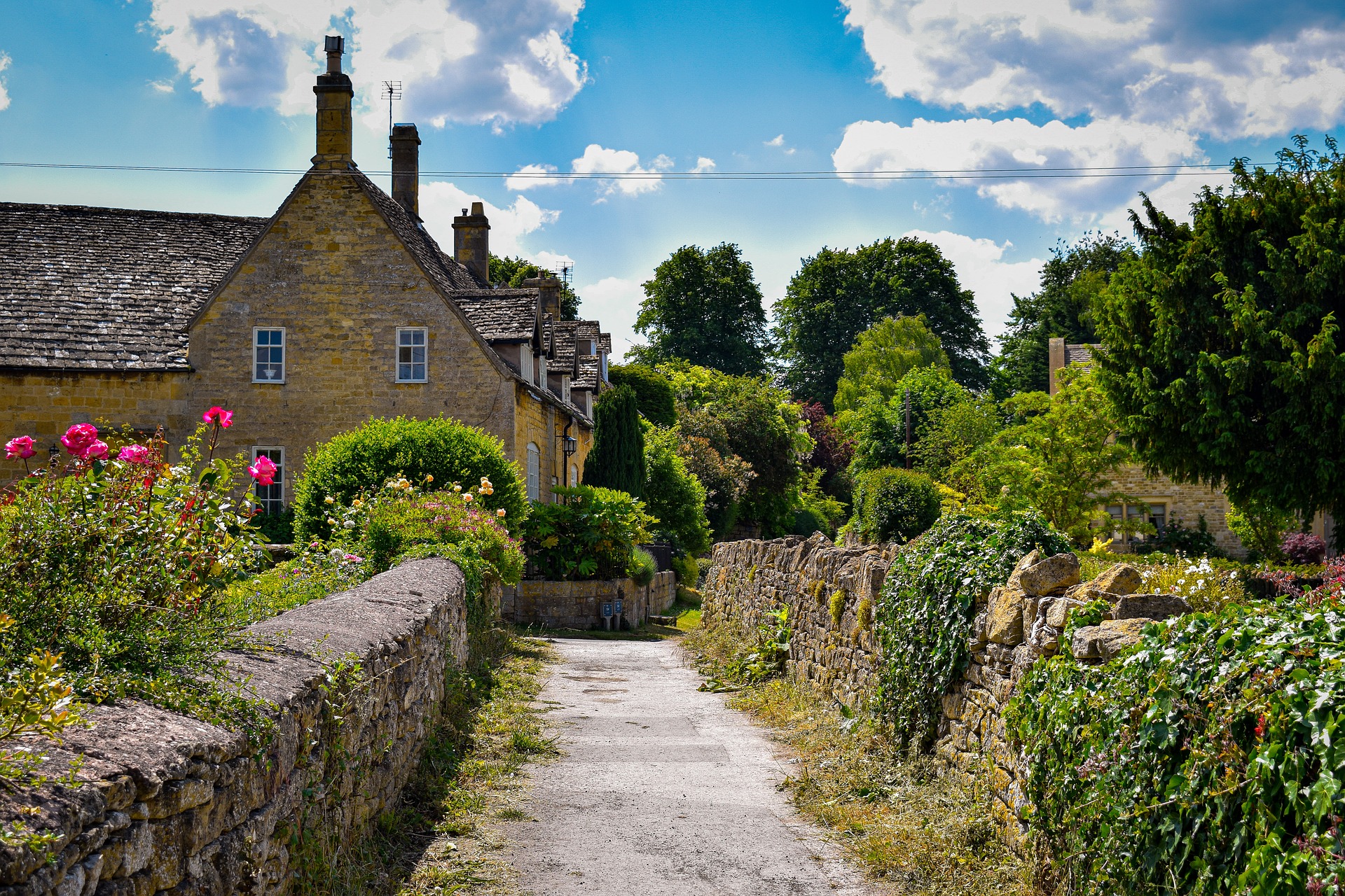 Charming stone house on a lane, Cotswolds, England region, springtime.